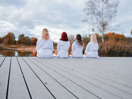 Frauen entspannen nach Sauna am Badesee mit Aperol