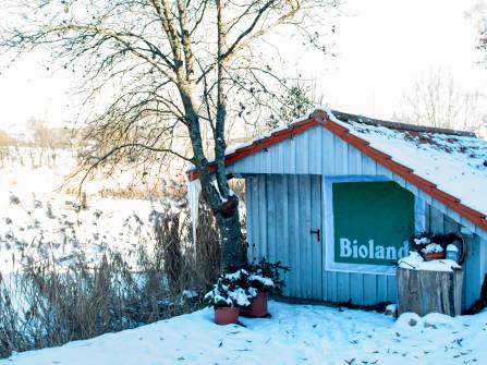 Holzhütte mit Bioland-Banner im Winter